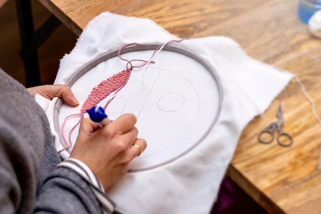 Osoba haftująca na ramce